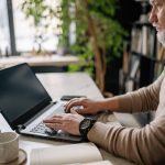 Man thinking how to become a better blogger and networker at laptop